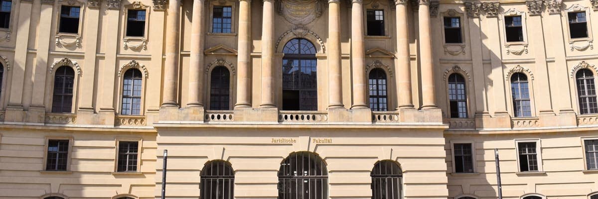 The stone facade of a historic German university building in Berlin.
